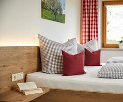 Gemütliches Bett mit Kissen in der Ferienwohnung im Oberallgäu