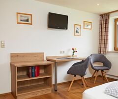 Wohnbereich mit Fernseher in der Ferienwohnung Grüntenblick
